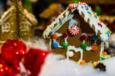 Renkli zencefilli kurabiye evi, bulanık arka planda, Noel süslemesiyle izole edilmiş..