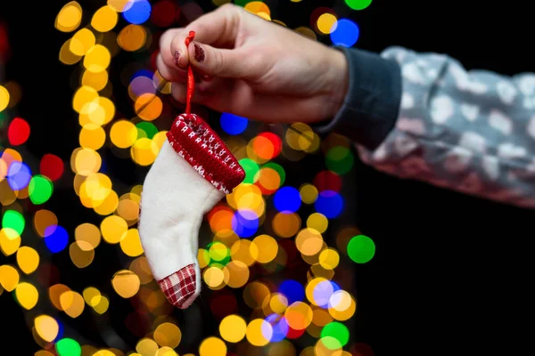 Woman\'s hands hold christmas decoration. Christmas and New Year holidays background, winter season with Christmas ornaments and blurred lights