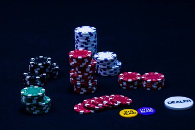 Siyah arkaplanda poker çipleri yığını