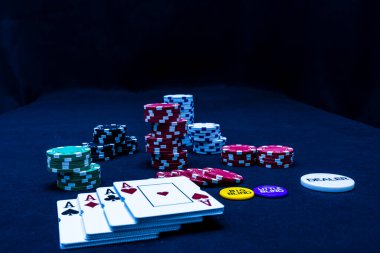 Siyah arkaplanda poker fişleri ve poker kartları yığını