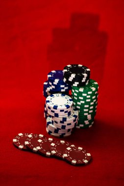 Kırmızı arkaplanda poker çiplerinin karışımı