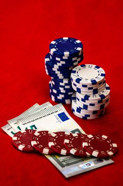 Kırmızı arkaplanda parası olan poker çipleri yığını, EURO para birimi