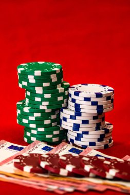 Kırmızı arkaplanda parası olan poker çipleri yığını, EURO para birimi