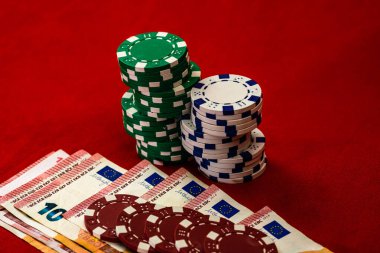 Kırmızı arkaplanda parası olan poker çipleri yığını, EURO para birimi