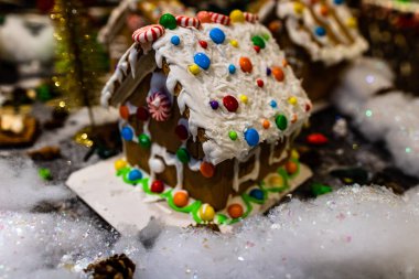 Renkli zencefilli kurabiye evi, bulanık arka planda, Noel süslemesiyle izole edilmiş..