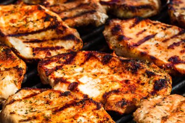 Izgara domuz bifteği. Lezzetli biftekler ızgarada yakın pişiyor.