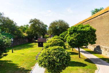 Temiz çimleri olan yeşil bir bahçe, güzel ağaçlar, kale avlusundaki sokaklar. Romanya 'nın Alba Iulia kentindeki surlar ve gezinti alanları, 2021