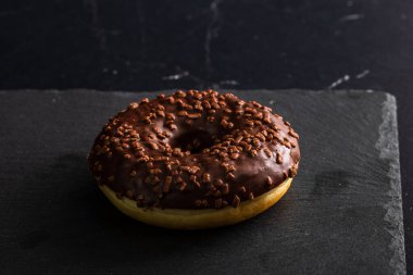 Çikolata kaplı çörek ve çikolata parçacıkları izole edilmiş. Lezzetli çörekleri yakın çekin..