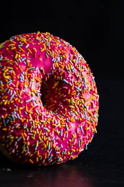 Pembe jöleli donut ve serpiştirilmiş serpiştirilmiş. Renkli çörekleri kapat.