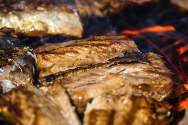 Kömür ızgarasında ızgara uskumru ve duman..