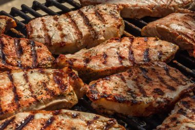 Izgara domuz bifteği. Lezzetli biftekler ızgarada yakın pişiyor.