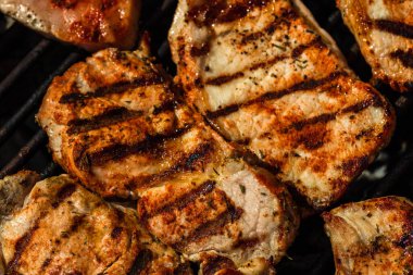 Izgara domuz bifteği. Lezzetli biftekler ızgarada yakın pişiyor.