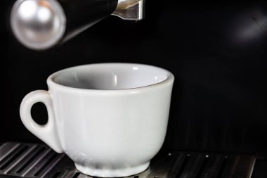 Kahve makinesini doldururken bir fincan espresso.