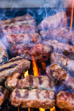 Mangalda mici ya da mititei denilen rulo köfteleri hazırlıyorum. Izgarayı alev ve dumanla yakın..