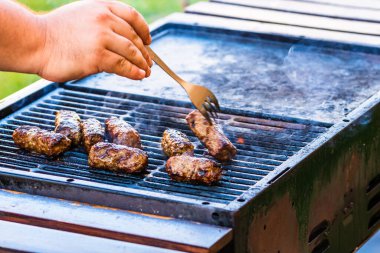 Mangalda mici ya da mititei denilen rulo köfteleri hazırlıyorum. Izgarayı alev ve dumanla yakın..