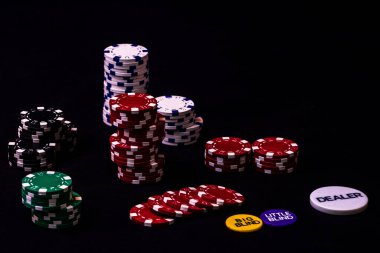Siyah arkaplanda poker çipleri yığını