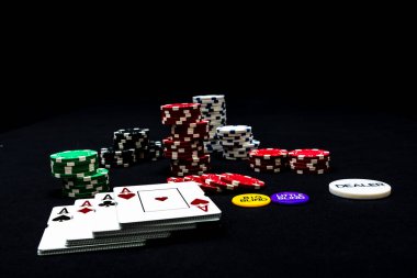 Siyah arkaplanda poker fişleri ve poker kartları yığını