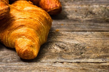 Tahtaya izole edilmiş lezzetli, taze kruvasanlar. Fransız kahvaltı konsepti.