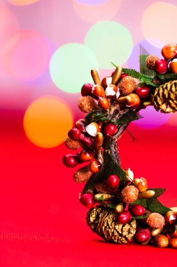 Bulanık ışıkların arka planında izole edilmiş renkli Noel çelenkleri.