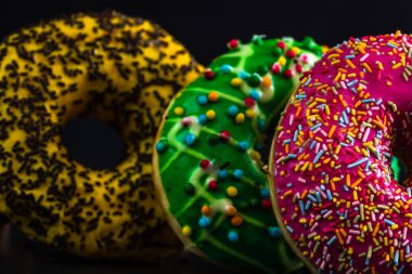 Şekerli donutlar izole edilmiş. Renkli donutları kapat.