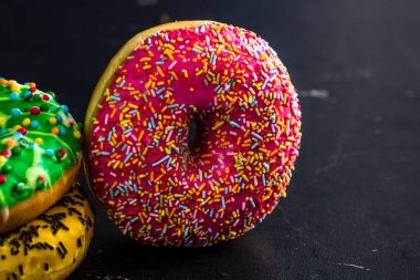 Şekerli donutlar izole edilmiş. Renkli donutları kapat.