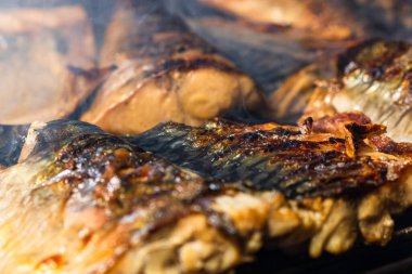 Kömür ızgarasında ızgara uskumru ve duman..