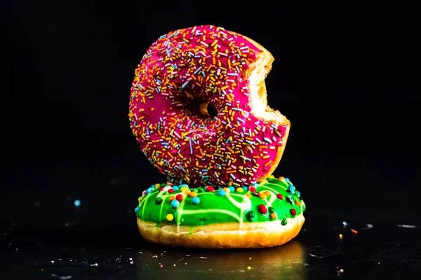 Isırılmış pembe jöleli donut. Renkli donutları kapat.