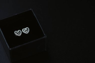 Siyah üzerine izole edilmiş güzel gümüş küpeler, yakın çekim.