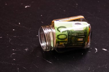 Cam bir kavanozda para biriktirme kompozisyonu. Yatırım yapma ve para tutma kavramı, tecrit edilmiş..