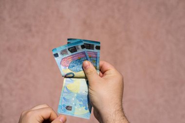 Avro parasını tutmak ve göstermek ya da para vermek. Dünya para kavramı, 20 EURO banknotları. Kopya alanı ile izole edilmiş para birimi. Zengin iş adamları kavramı, para biriktirmek ya da harcamak.