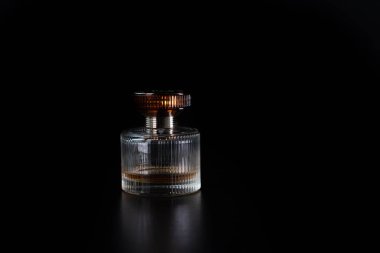 Siyah arka planda izole edilmiş şık bir parfüm şişesi..