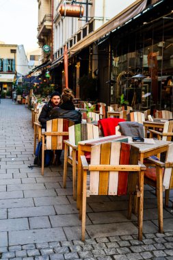 Romanya 'nın Bükreş kentindeki bir açık hava restoranında boş sandalyeli boş masaları kapat, 2021