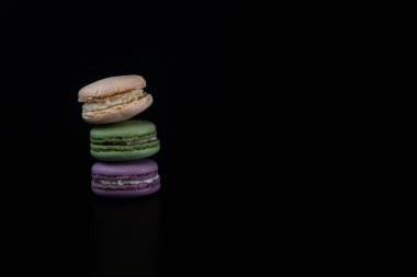 Siyah arka planda izole edilmiş rengarenk badem kurabiyeleri, Fransız badem kurabiyeleri.