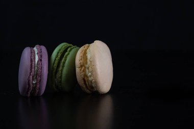 Siyah arka planda izole edilmiş rengarenk badem kurabiyeleri, Fransız badem kurabiyeleri.