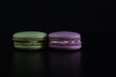 Siyah arka planda izole edilmiş rengarenk badem kurabiyeleri, Fransız badem kurabiyeleri.