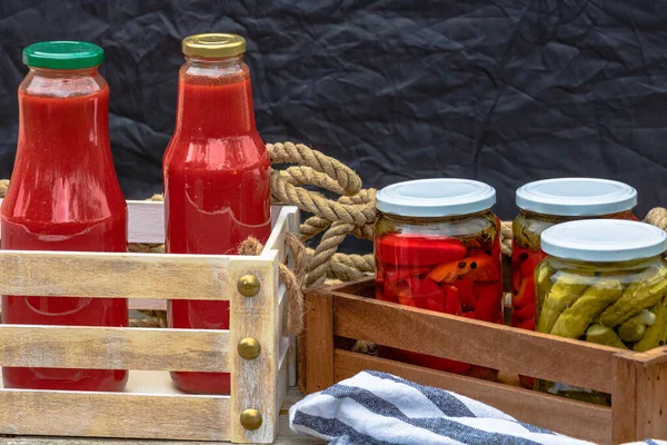 Bottles of tomato sauce, preserved canned pickled food concept isolated in a rustic composition.