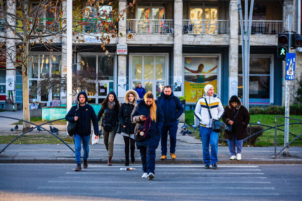 Люди движутся, гуляя по улицам в центре Бухареста, Румыния, 2021