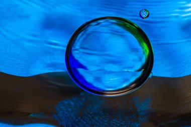 Su yüzeyinde yağ damlaları ve dalgaları olan soyut renkli arkaplan. Soyut arkaplan kavramı