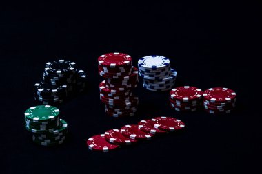 Siyah arkaplanda poker çipleri yığını