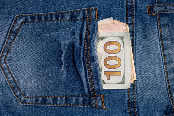USD money in back pocket of jeans. Woman wearing blue jeans with USD money in the back poket.