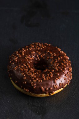 Çikolata kaplı çörek ve çikolata parçacıkları izole edilmiş. Lezzetli çörekleri yakın çekin..