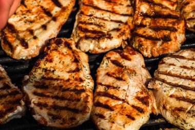 Izgara domuz bifteği. Lezzetli biftekler ızgarada yakın pişiyor.