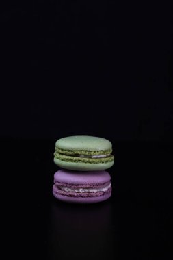 Siyah arka planda izole edilmiş rengarenk badem kurabiyeleri, Fransız badem kurabiyeleri.