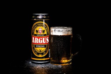 Bir kutu Argus birası ve arka planda bira bardağı. Romanya 'nın Bükreş kentinde 2021 yılında çekilen illüstrasyon fotoğrafı