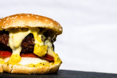 Beyaz arka planda erimiş peynirli taze sığır etli çizburger.