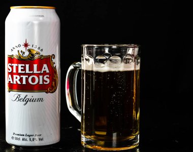 Bir kutu Stella Artois birası ve arka planda bira bardağı. Romanya 'nın Bükreş kentinde 2021 yılında çekilen illüstrasyon fotoğrafı
