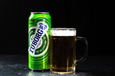 Siyah arka planda bir kutu Tuborg birası ve bira bardağı. Romanya 'nın Bükreş kentinde 2021 yılında çekilen illüstrasyon fotoğrafı