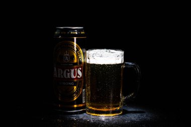 Bir kutu Argus birası ve arka planda bira bardağı. Romanya 'nın Bükreş kentinde 2021 yılında çekilen illüstrasyon fotoğrafı