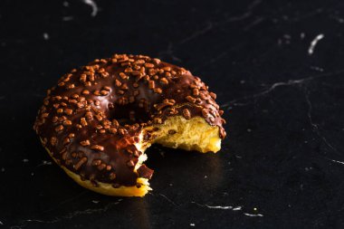 Siyah arka planda serpiştirilmiş taze renkli çörekler.