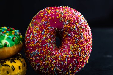 Pembe jöleli donut ve serpiştirilmiş serpiştirilmiş. Renkli çörekleri kapat.